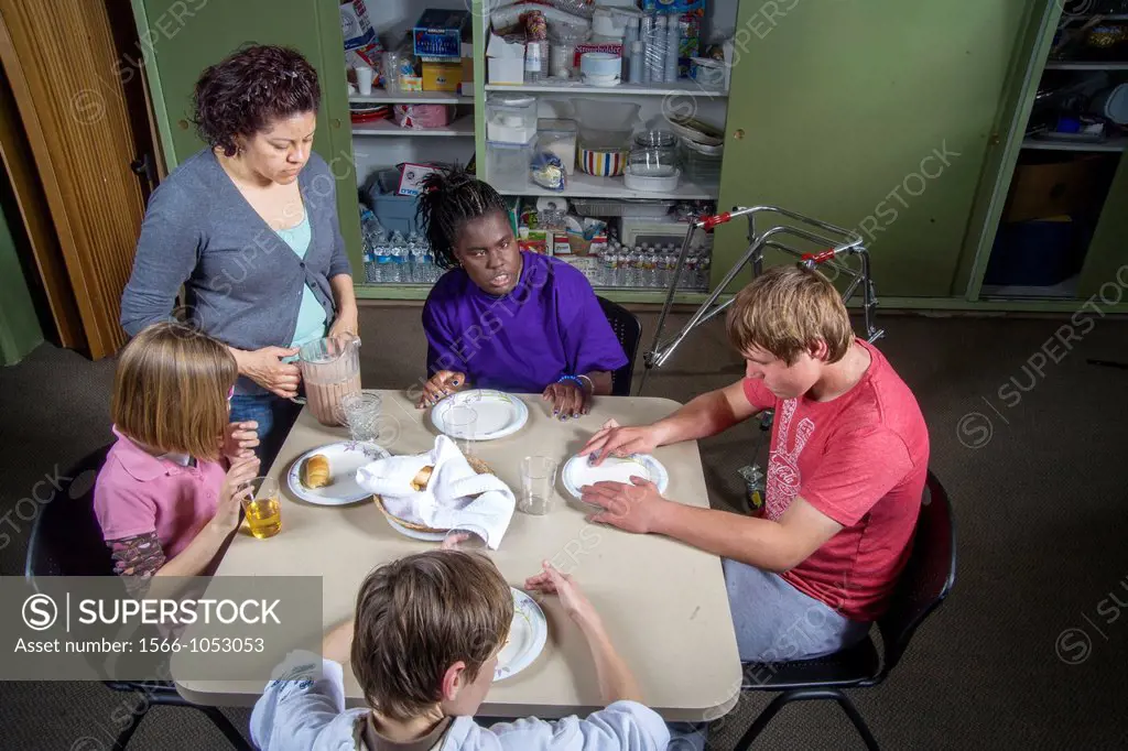 A teacher joins her blind and handicapped students sampling food they made in a baking and cooking class at the Blind Children´s Learning Center in Sa...