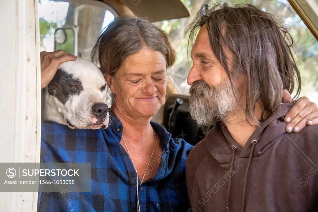 An affectionate indigent couple and their dog live in a truck camper among homeless residents of a primitive outdoor encampment in the desert town of ...
