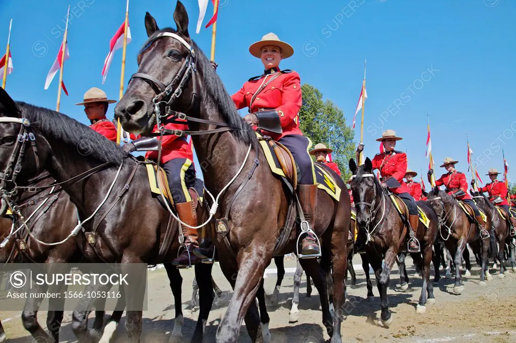 A procession of RCMP officers in scarlet jackets after their musical ride event