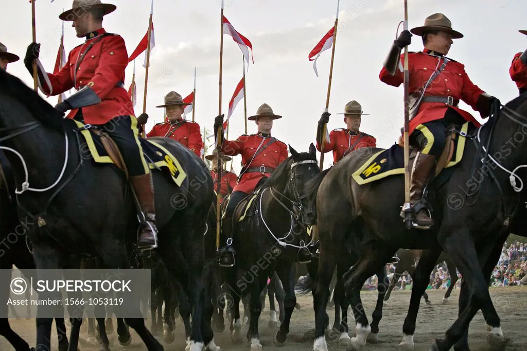 RCMP officers in scarlet jackets riding their horses in a routine during their musical ride event