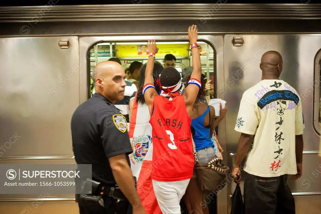 Revelers crowd the Number One train at the Columbus Circle station, traveling up to Washington Heights, after the Dominican Day parade in New