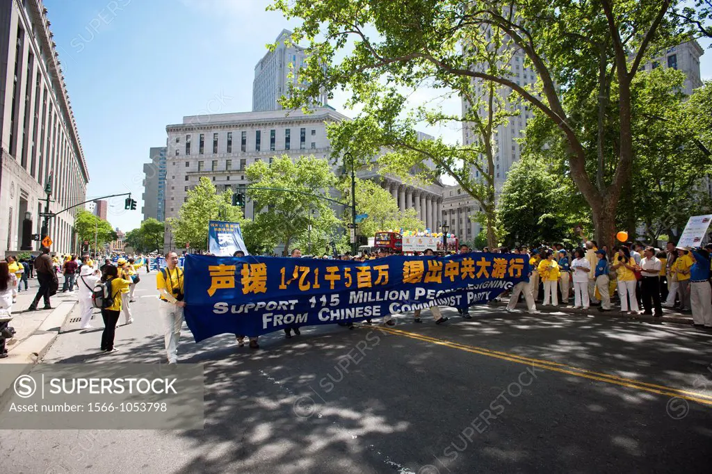 Carrying banners and signs members of Falun Dafa Falun Gong from around the world parade through the streets of Chinatown in New York Practitioners of...