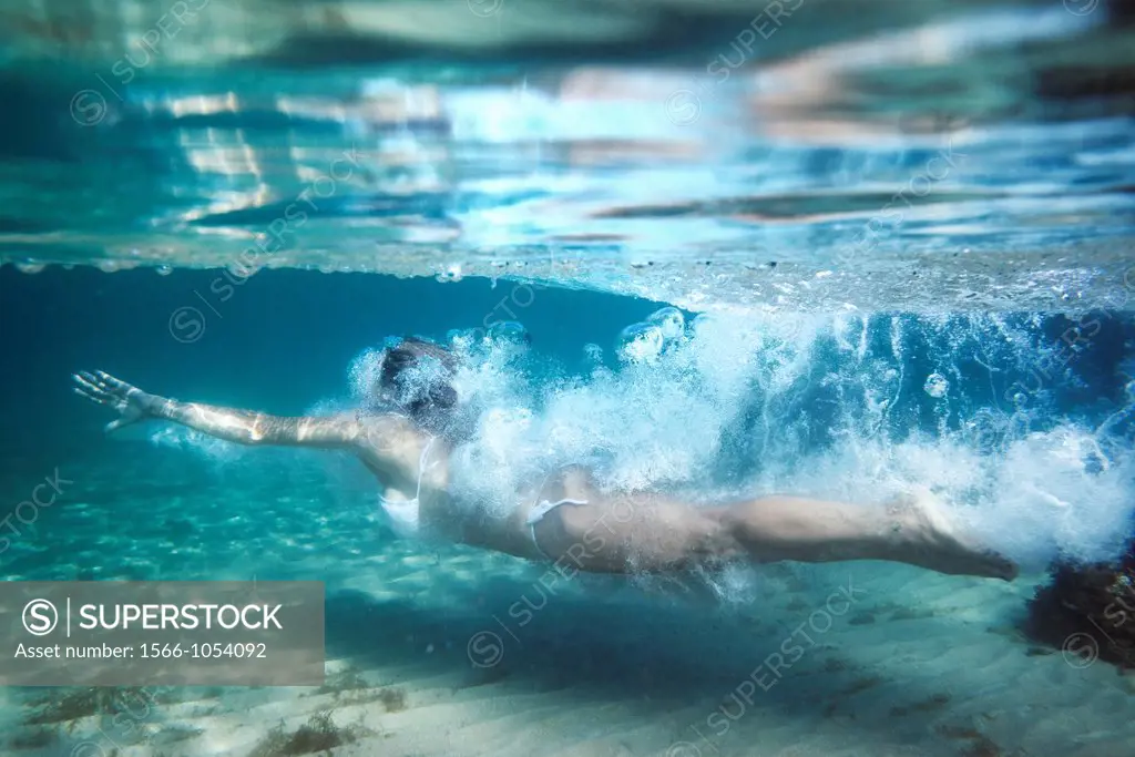 Woman diving underwater.