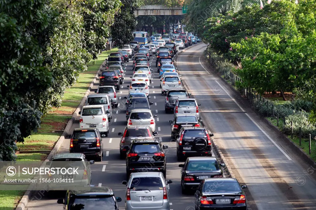 Heavy traffic seen from backside and from above on Jalan Sudirman with separated bus lane, Central Business District of Jakarta, Indonesia, Southeast ...