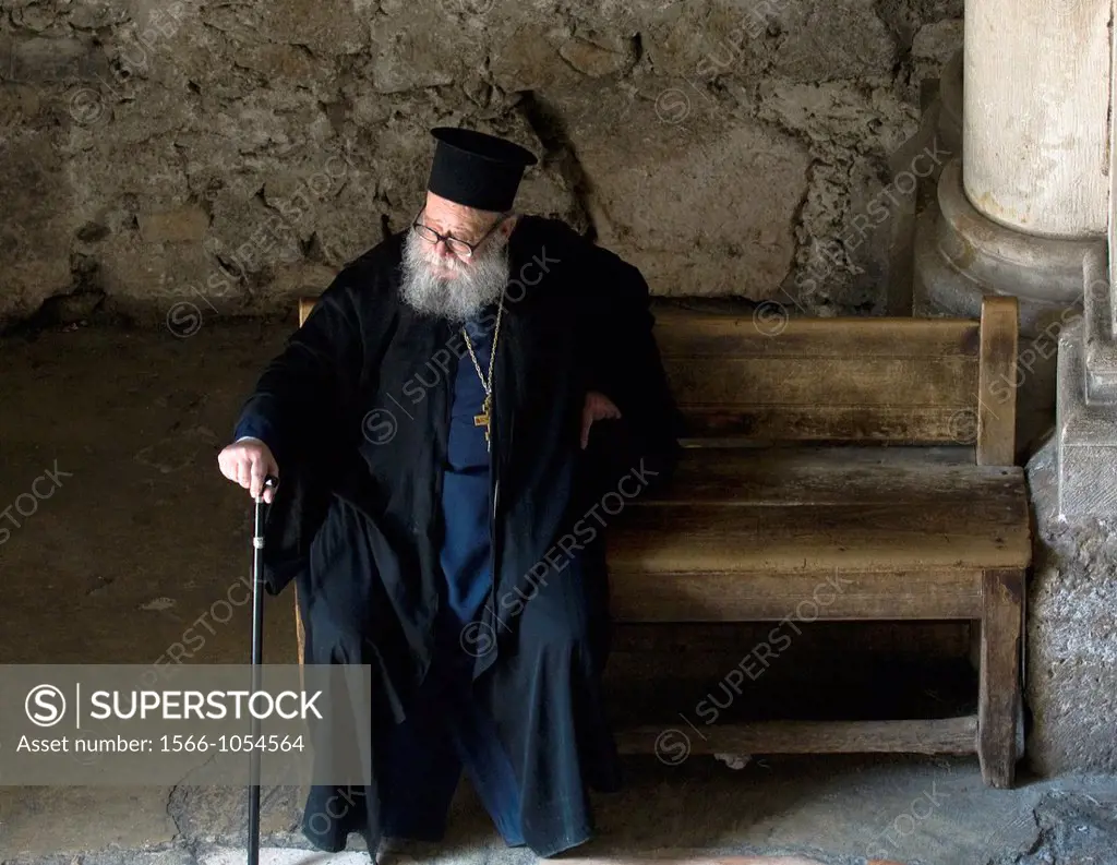 A Greek Orthodox priest resting at the entrance of the church of the holy Sepulcher in Jerusalem
