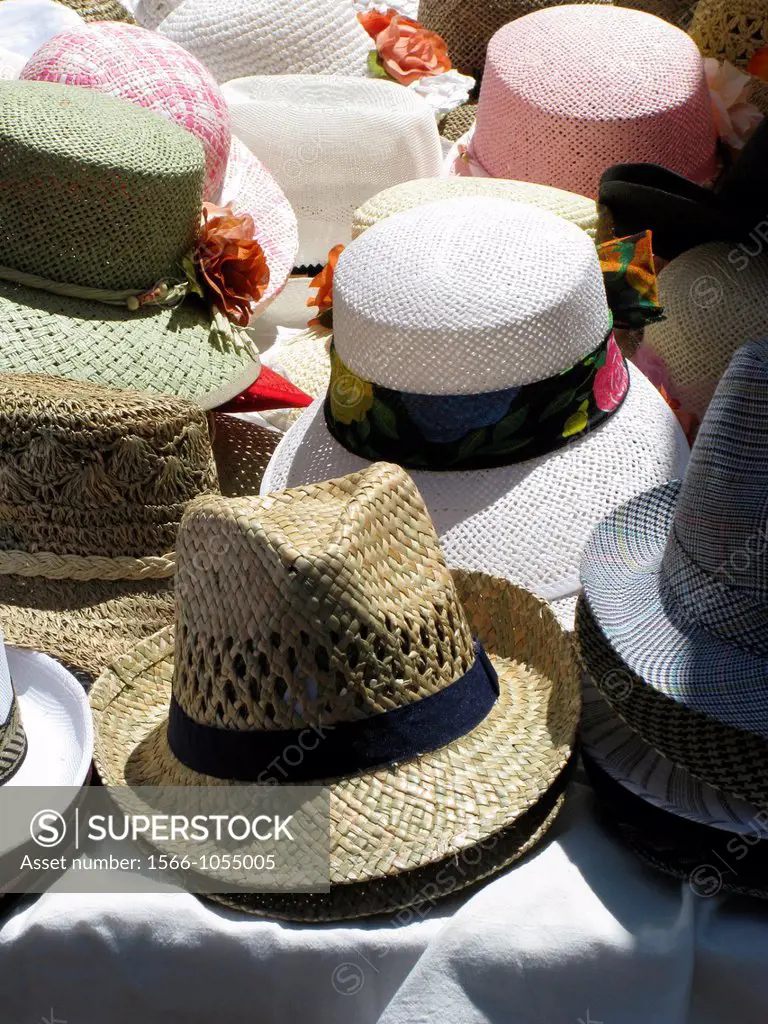 selection of straw hats on outdoor market stall