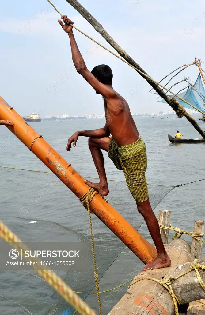 Indian man working with chinese fishing nets in Kochi,Kerala,South India,India,Asia