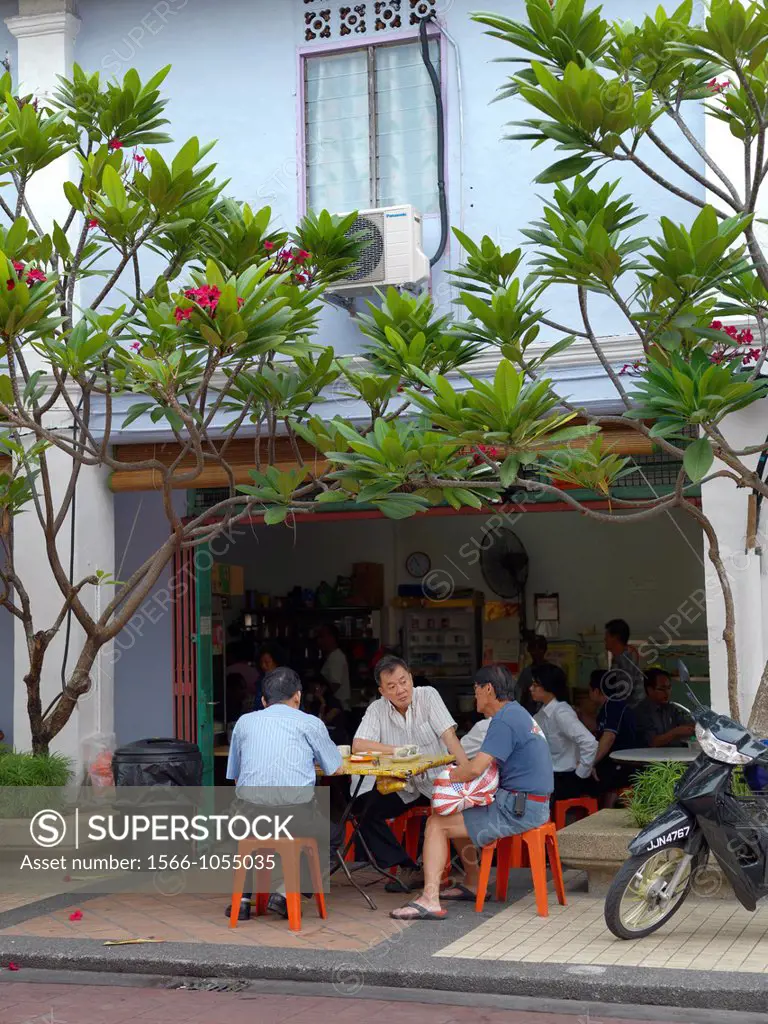 Older Malaysian men having a meal on the sidewalk of an outdoor cafe and restaurant in Johor Malaysia