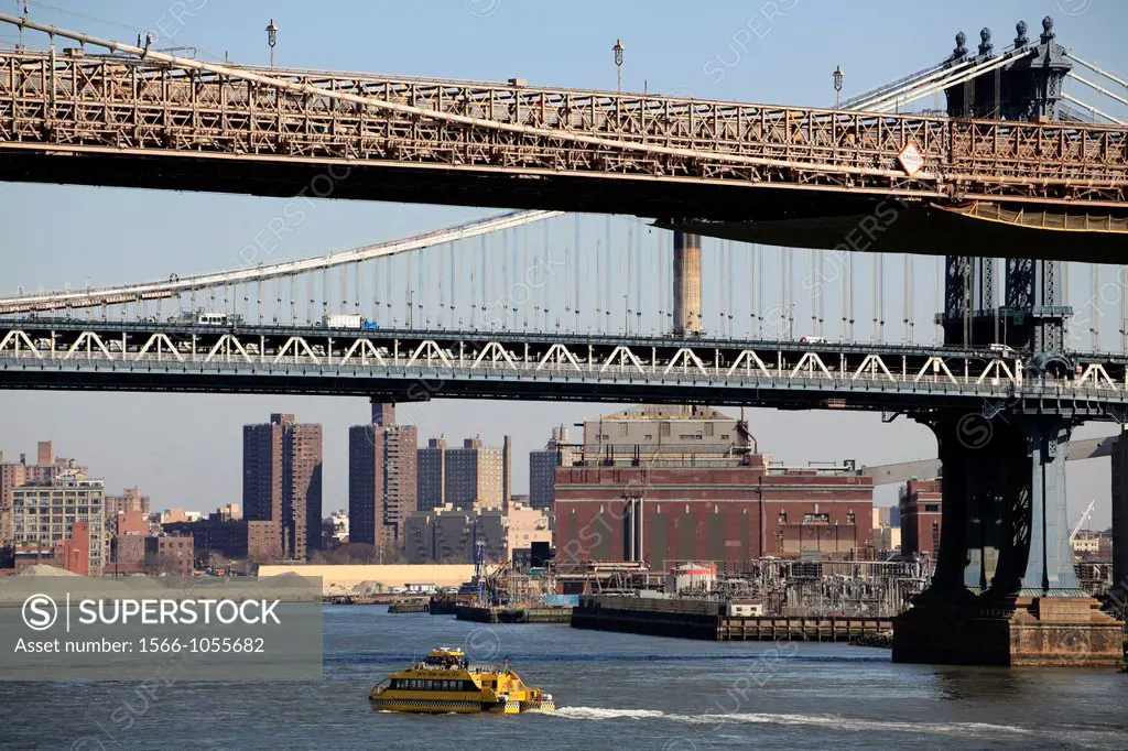 A East River water taix under Brooklyn Bridge with Manhattan Bridge in the background  New York City  New York  USA.