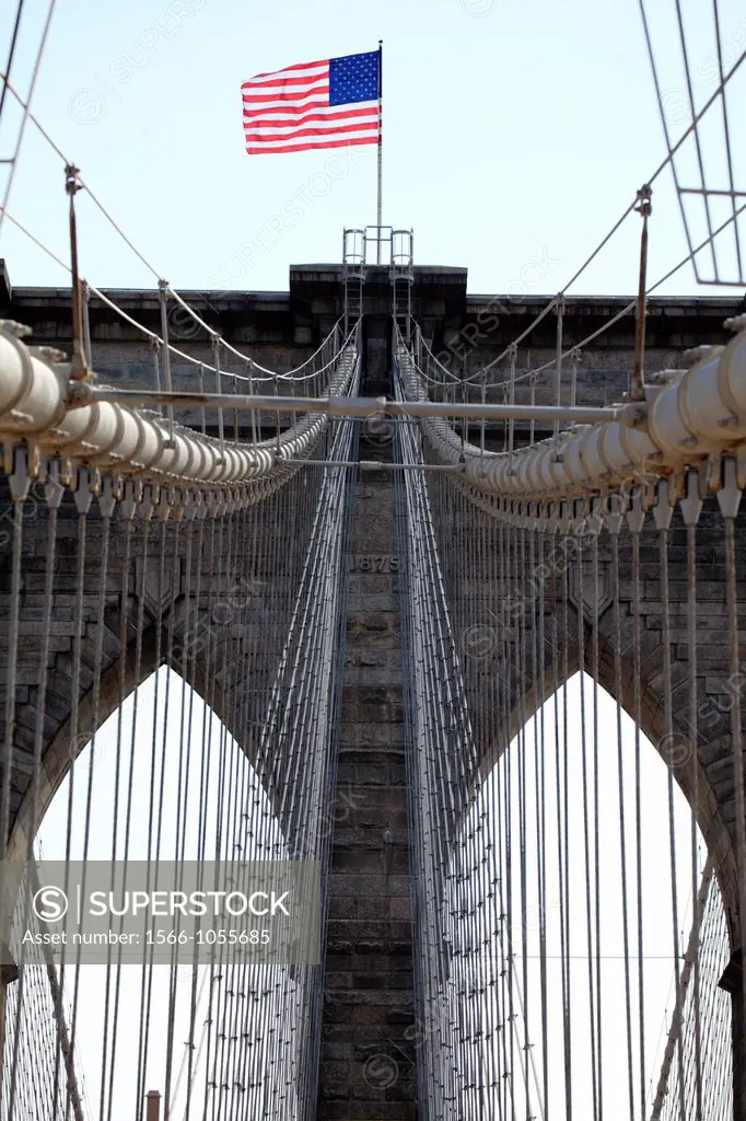 The view of neo-Gothic tower of Brooklyn Bridge from pedestrian walkway with suspension steel cables in foreground  New York City  New York  USA.