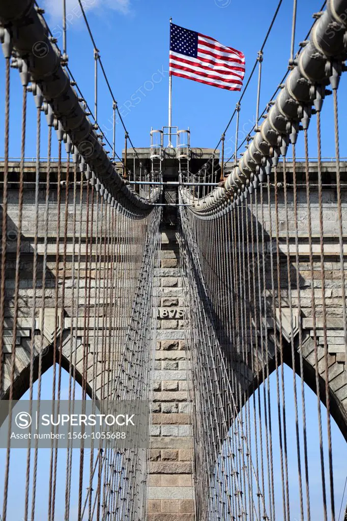 The view of neo-Gothic tower of Brooklyn Bridge from pedestrian walkway with suspension steel cables in foreground  New York City  New York  USA.