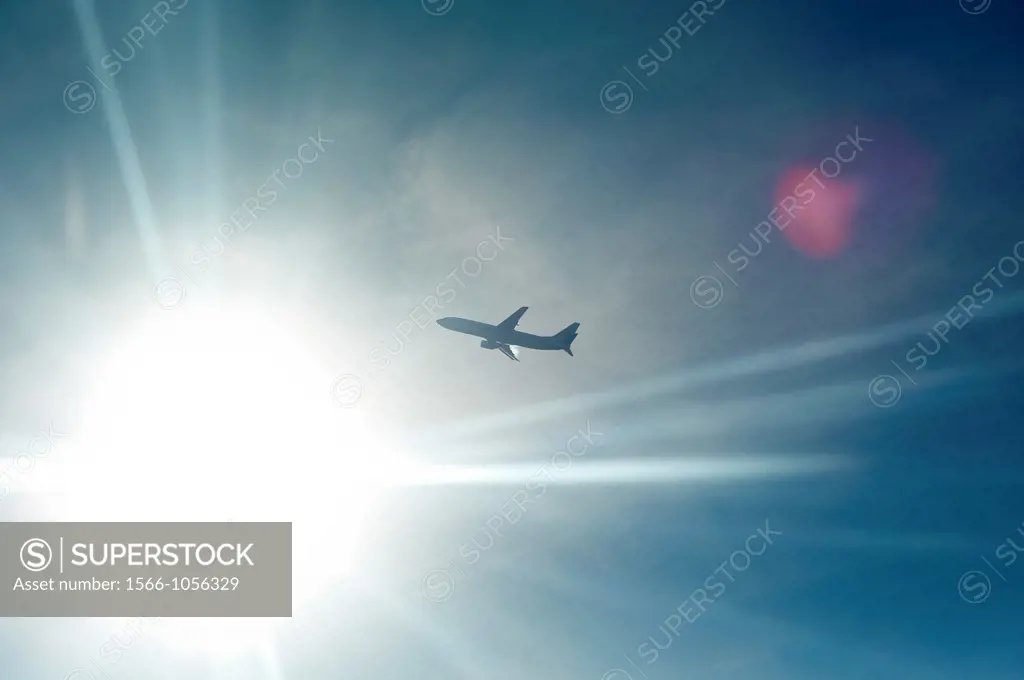 An airplane backlit by the sun in midair