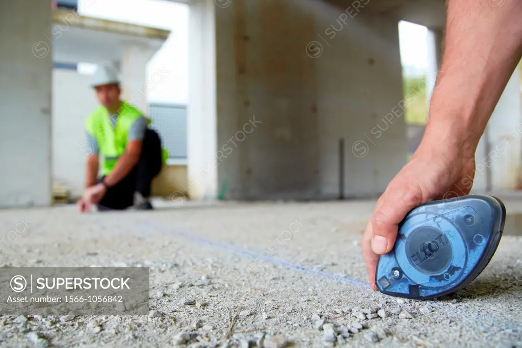 Workers with personal protective equipment, PPE, Marking guide lines for the construction of interior walls, Line tracer, housing construction, concre...