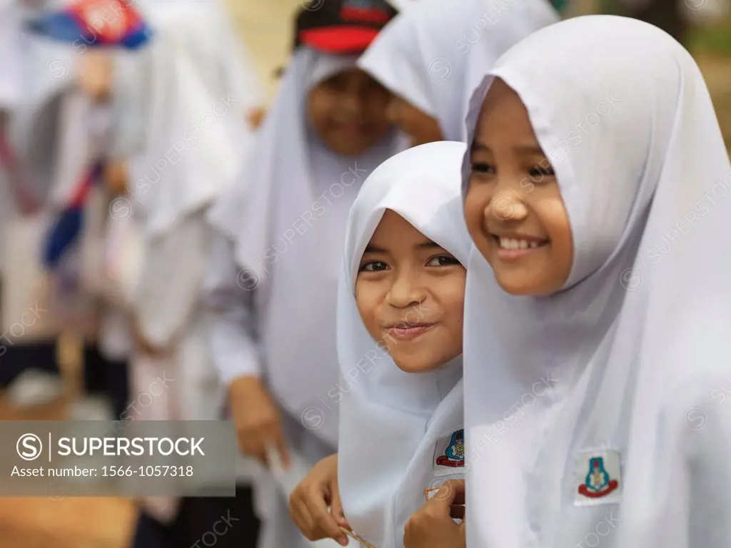 Young girls dressed in traditional muslim garbs smiling