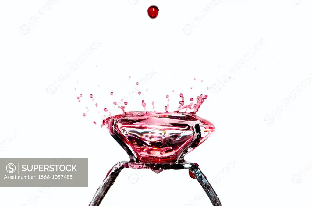 Red water drops falling on a diamond ring