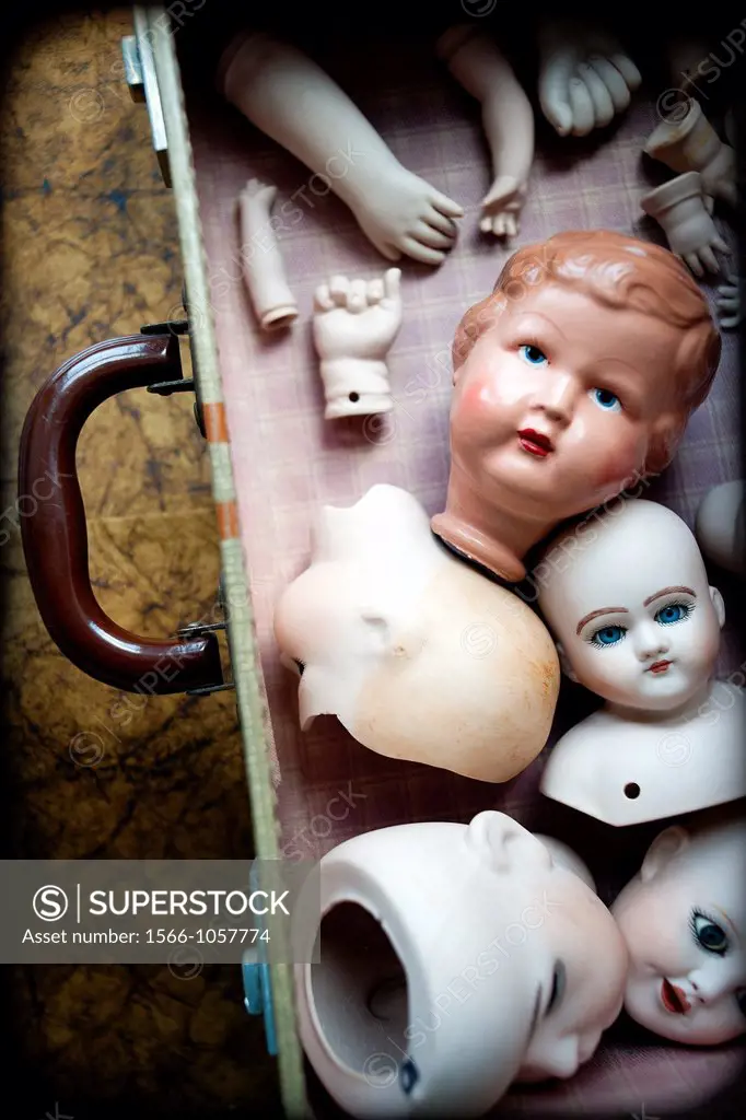 Many porcelain heads and arms together in a suitcase,
