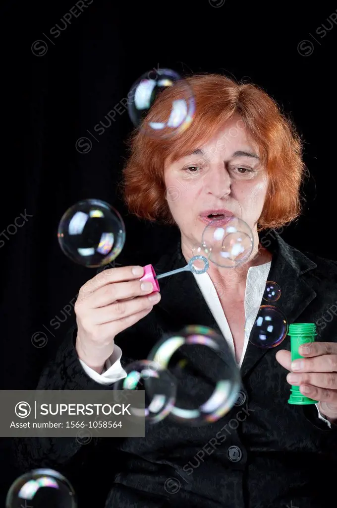 Middle aged woman blowing bubbles