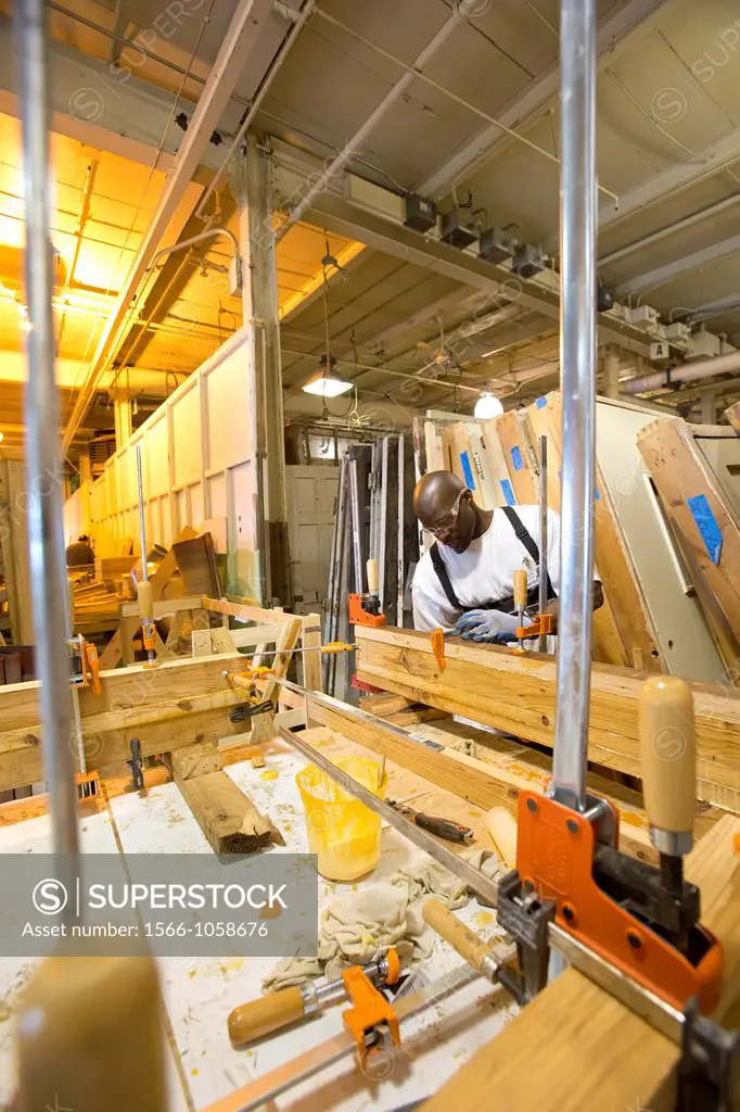 Detroit, Michigan - A worker glues together reclaimed lumber to make butcher-block counter tops at a warehouse operated by the nonprofit WARM Training...