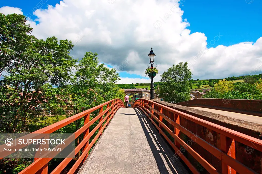Wooden bridge with a pedestrian in Pateley Bridge on a sunny, Summer day. Yorkshire, England.