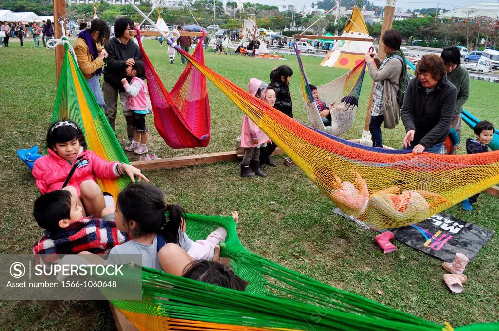 Nago Japan: children having fun on hammocks during the first commemoration of Fukushimas disaster  