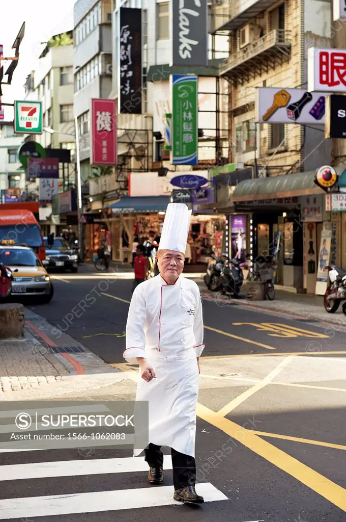 Head Chef Huang Lai Fa of The Grand Formosa Regent Hotel Taipei, posing and sampling food on Yongkang Street in Taipei, Taiwan