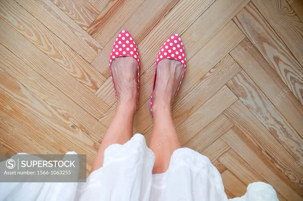 Woman´s feet on wooden floor