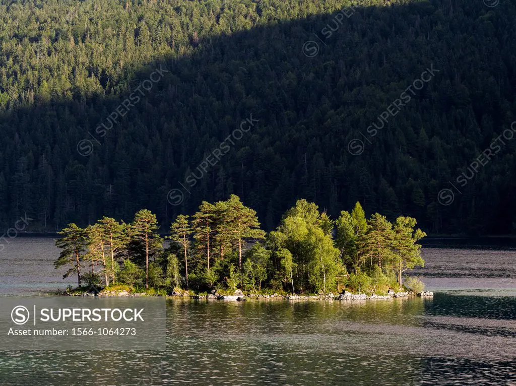 Island in Lake Eibsee during evening  Lake Eibsee is close to Garmisch-Partenkirchen in county Werdenfelser Land  Lake Eibsee is one of the major natu...