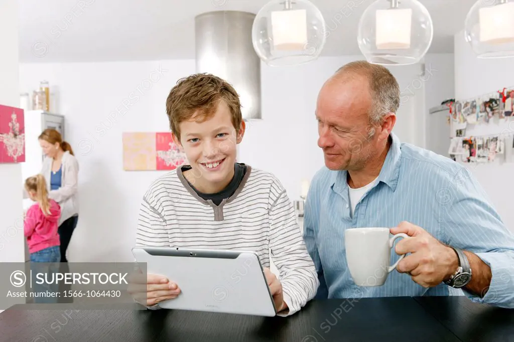 Father and son using tablet computer at home