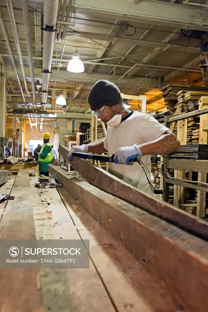 Detroit, Michigan - Workers clean lumber and prepare it for re-use at a warehouse operated by the nonprofit WARM Training Center  The lumber was salva...