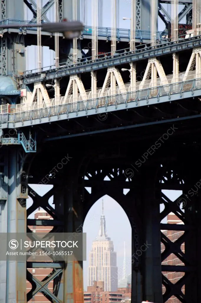 The view of Empire State Building through the arch of the steel tower of Manhattan Bridge in Brooklyn  New York City  New York  USA.