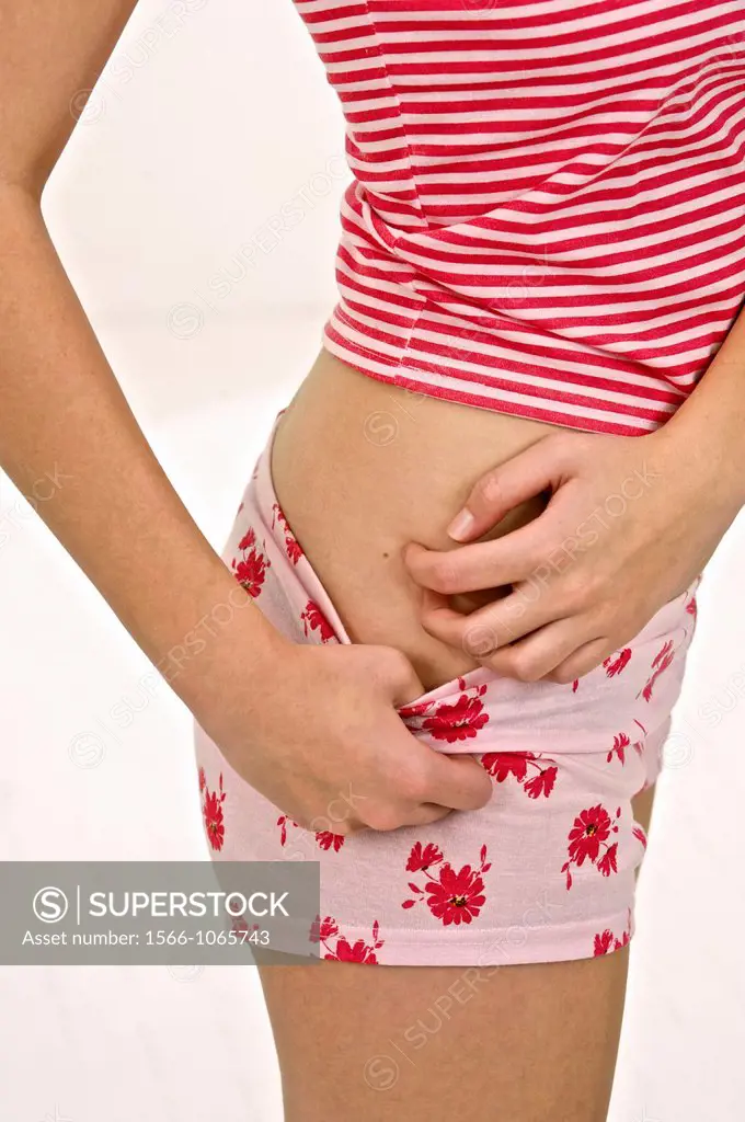 arms of young woman scratching her itching hip in red underwear