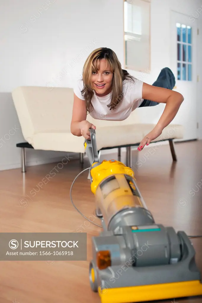 Woman hovering in air levitation style while vacuum cleaning the house