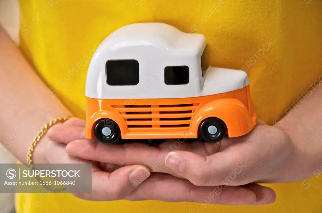 Two woman´s hands holding a toy car to symbolize driving or driving licence