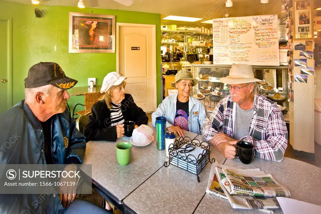 Local people their enjoy morning coffee and conversation at a Main Street restaurant in Kanab, Utah  Note sign in background