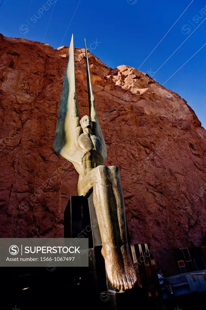 The setting sun illuminates one of the two bronze ´Angels Statues´ by sculptor Oskar Hansen decorating Hoover Dam on the Colorado River in Nevada