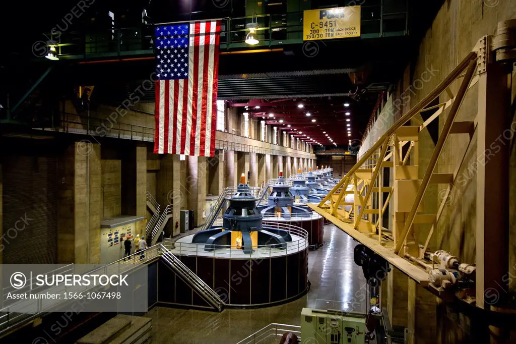 An American flag decorates one of the hydroelectric power plants at Hoover Dam on the Colorado River  Note workmen in left foreground