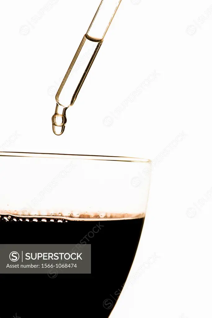 Pipette putting toxic substance in glass filled with red wine