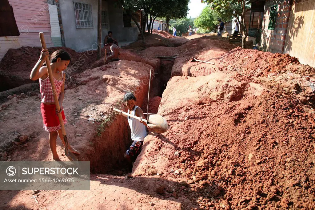 Poor communities building a sewerage system in their slum The government provides the materials