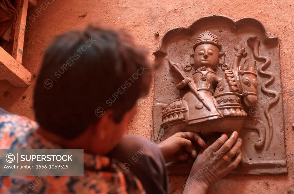 Potter working on an altar representing a hindu deity : Tejaji, a local god who cures snake bites. From Rajasthan, India.