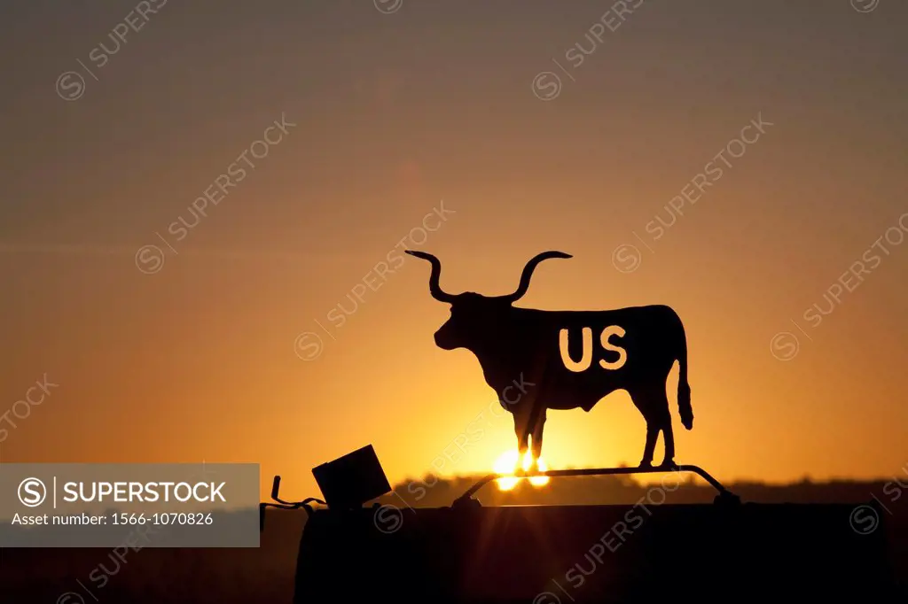 Valentine, Nebraska - A setting sun shines through an image of a Texas longhorn cow on the U S  Fish and Wildlife Service mailbox at the Fort Niobrara...