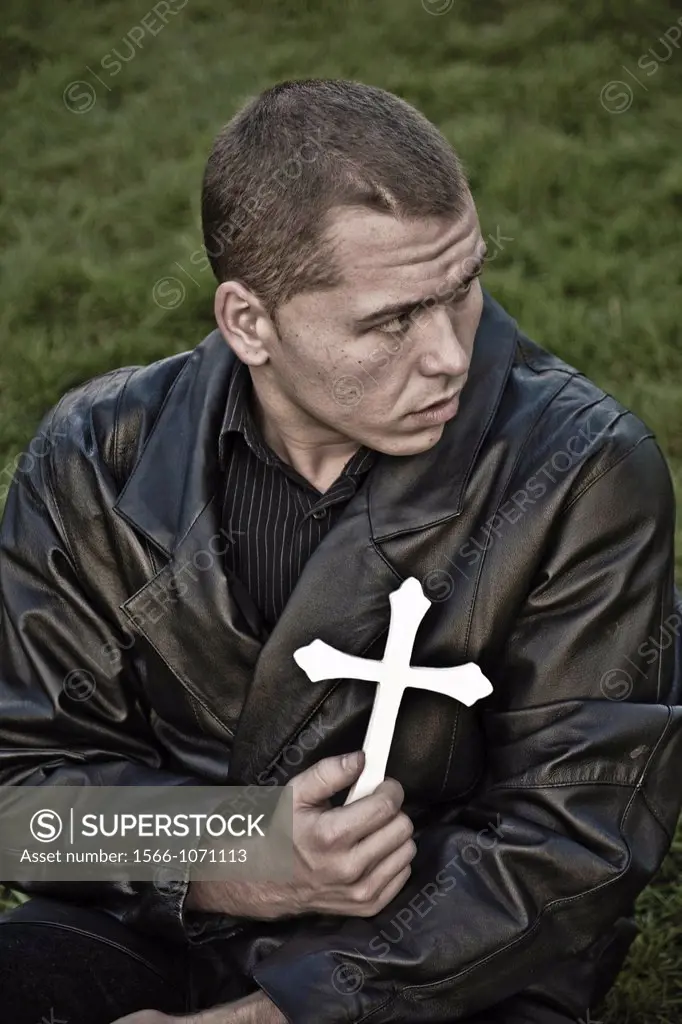 Young man holding a cross
