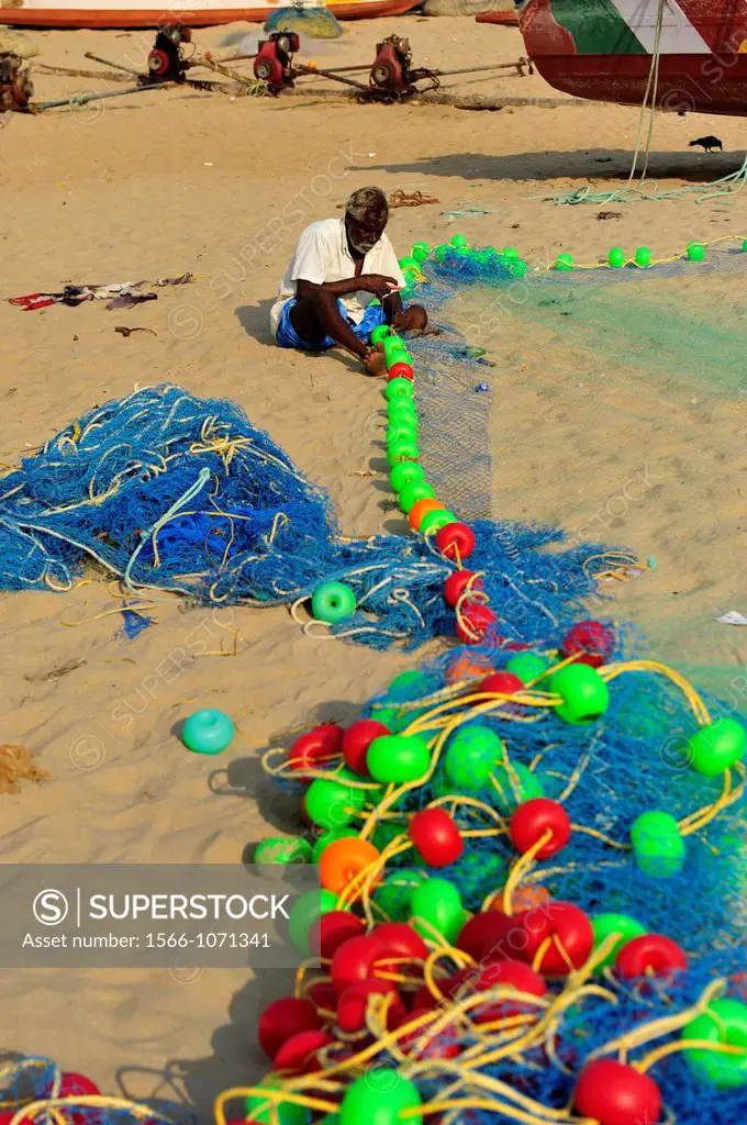 Fisherman repairing fishing net in Mamallapuram beach,Tamil Nadu,South India,Asia