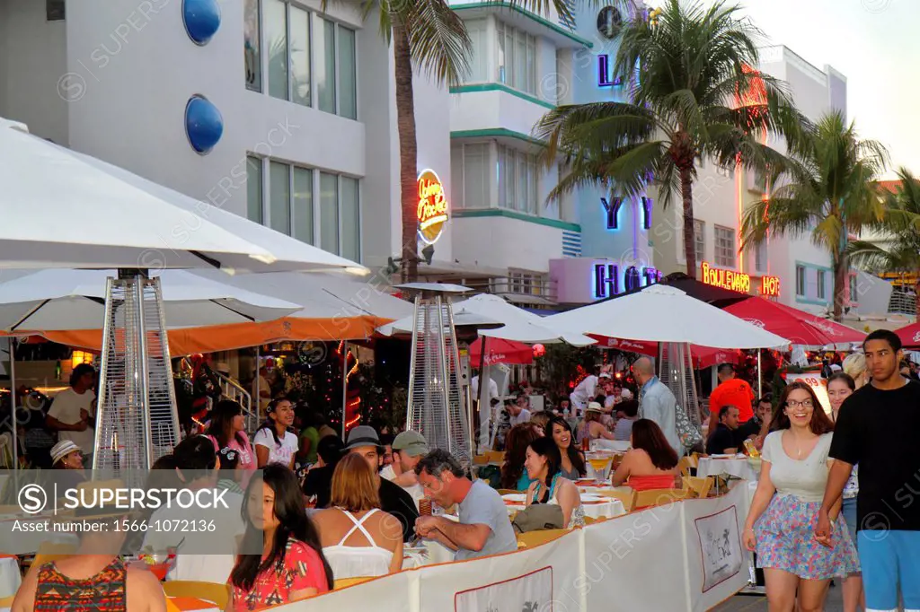 Florida, Miami Beach, Ocean Drive, Art Deco Historic District, hotels, restaurant, alfresco, dining, umbrellas, couple, Black, man, Asian, woman,