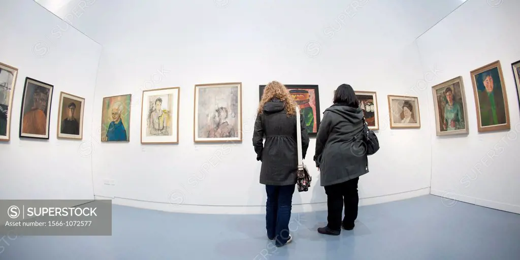 People looking at an exhibition of paintings Aberystwyth Arts Centre, Wales UK
