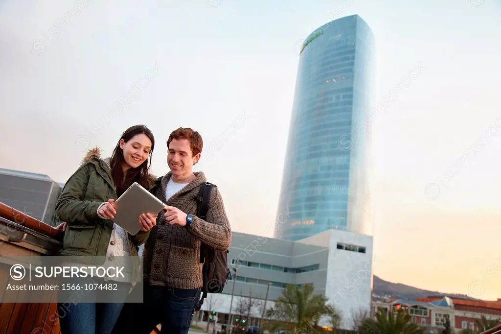 Couple searching on digital tablet in city, digital tablet, Iberdrola Tower, Abandoibarra, Bilbao, Bizkaia, Basque Country, Spain