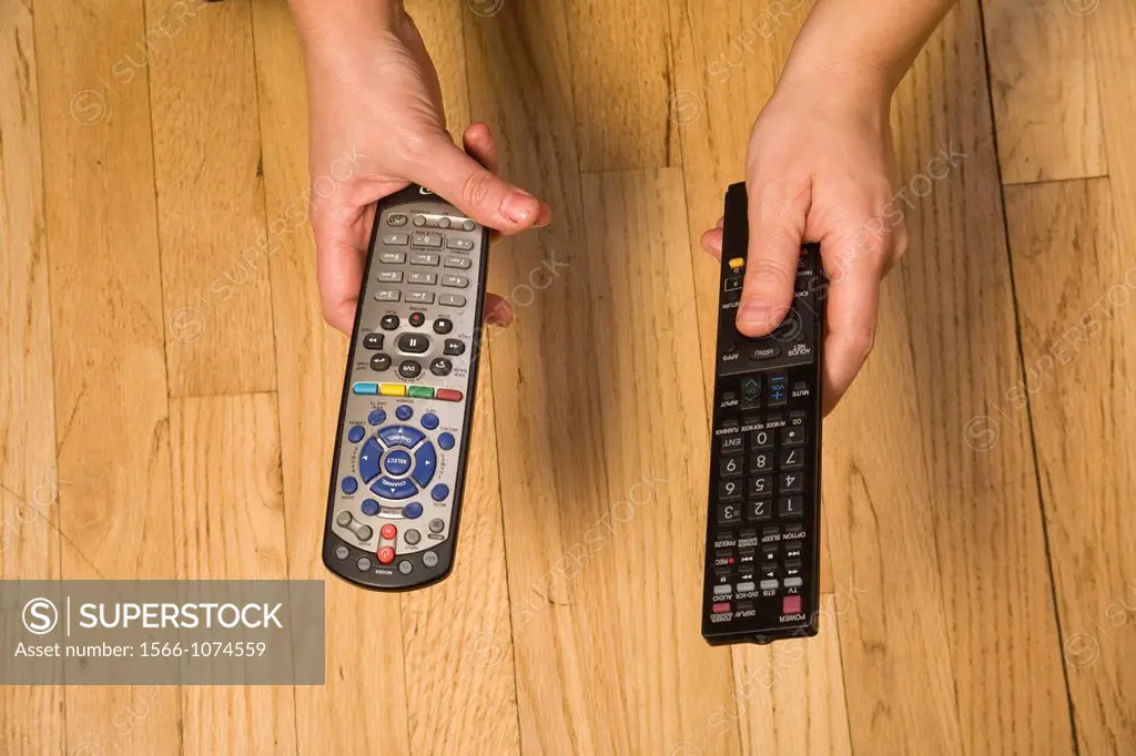 Woman´s hands holding remote controls