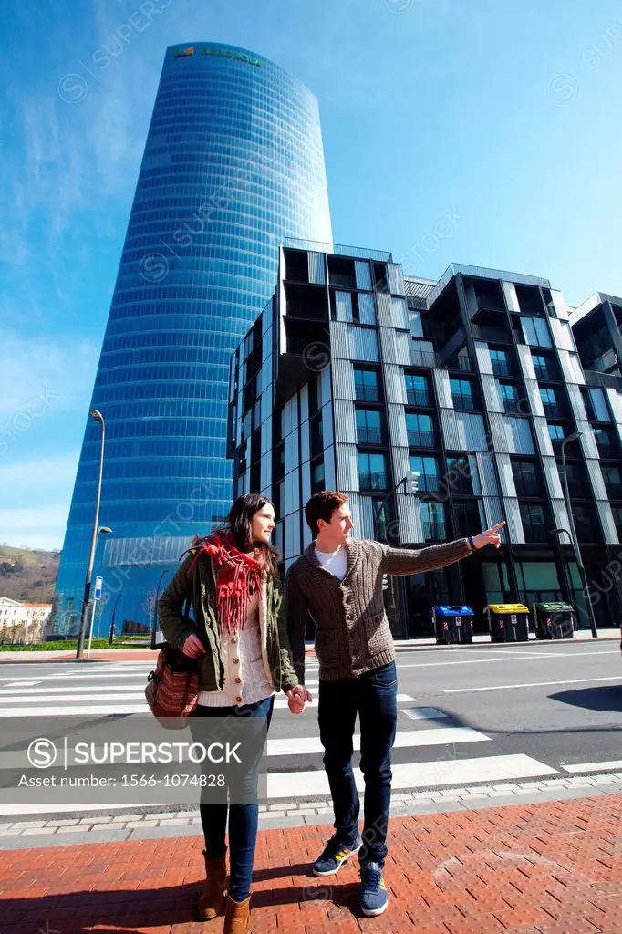 Young couple walking, Iberdrola Tower, designed by Cesar Pelli, Abandoibarra, Bilbao, Bizkaia, Basque Country, Spain