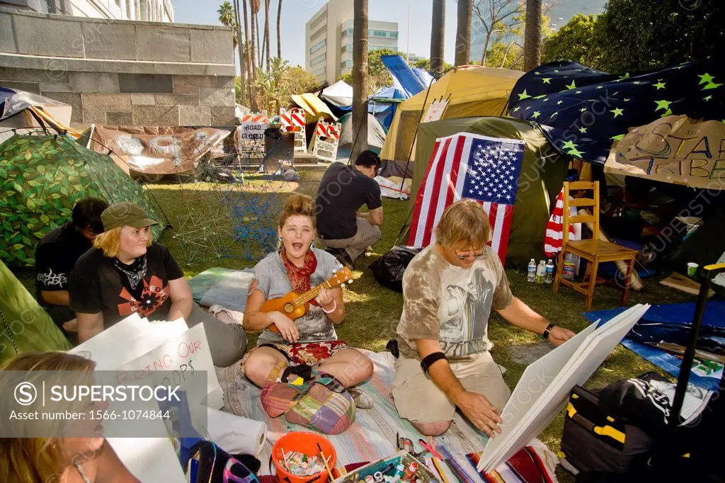 A member of the Occupy Wall Street protest encampment at Los Angeles City Hall in October, 2011, makes a protest while another plays the ukulele  Note...
