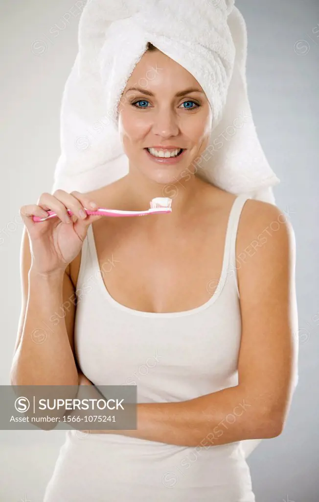 Attractive young woman brushing her teeth