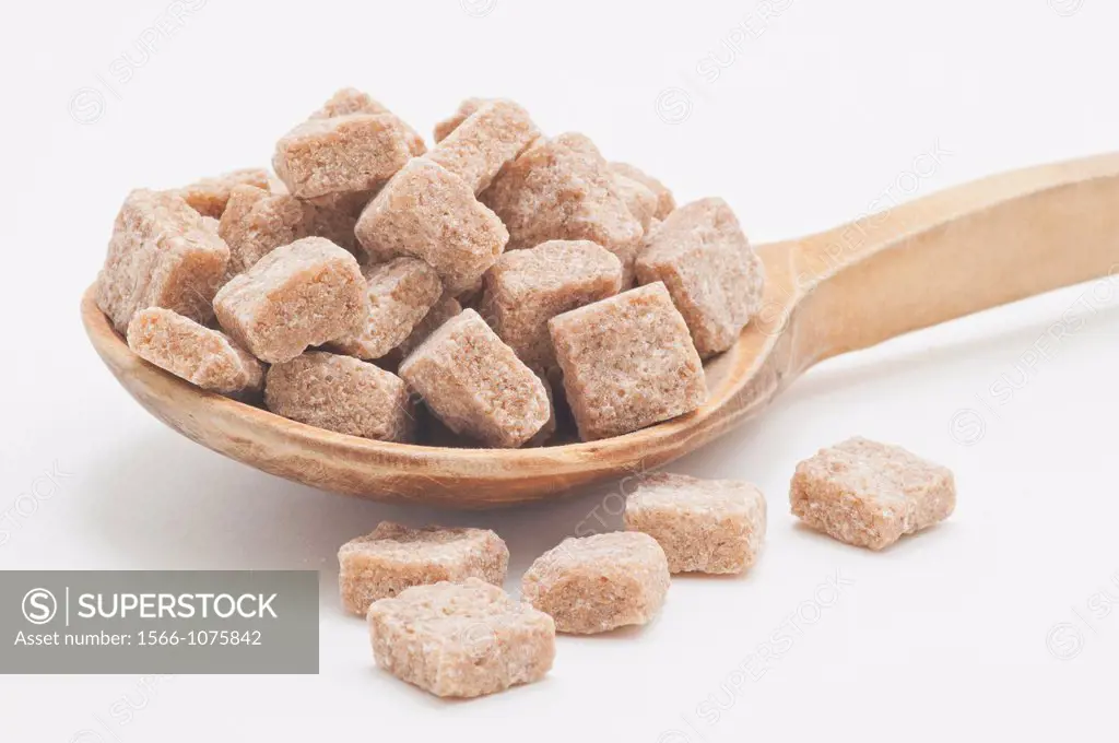 Brown sugar cubes on a wooden spoon